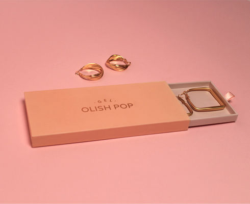 Pequenas caixas de papelão com logotipo rosa e ouro